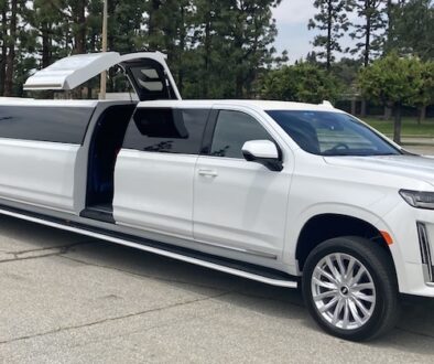 A white luxury SUV with gullwing doors open, revealing a spacious interior.