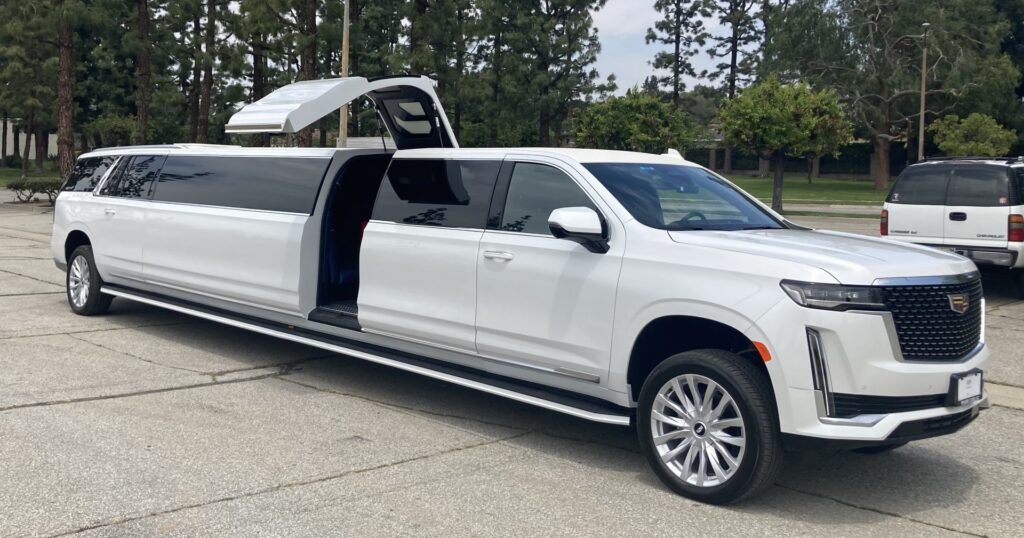 A white luxury SUV with gullwing doors open, revealing a spacious interior.