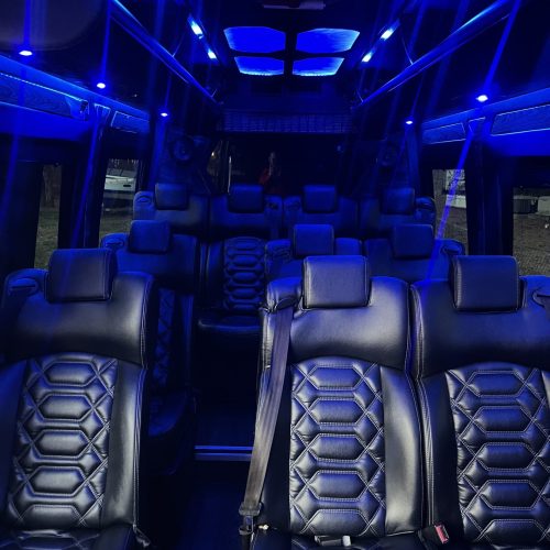 Party van interior with quilted leather seats and glowing blue ceiling.