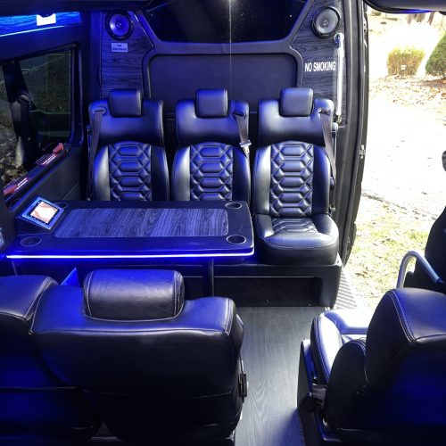 Interior shot with quilted black leather seats and cup holders.